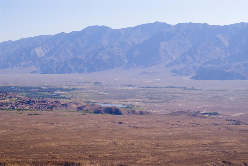 a flat valley in califronia surrounded by and impressive range of montains