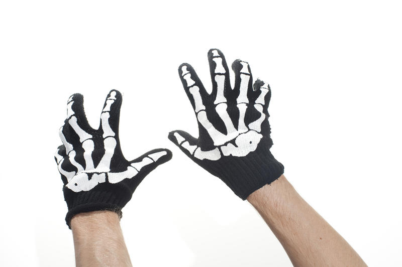 hands wearing a pair of halloween skeleton gloves