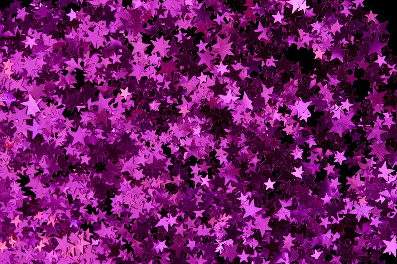 a colorful reflective backdrop of magenta pink metallic confetti stars