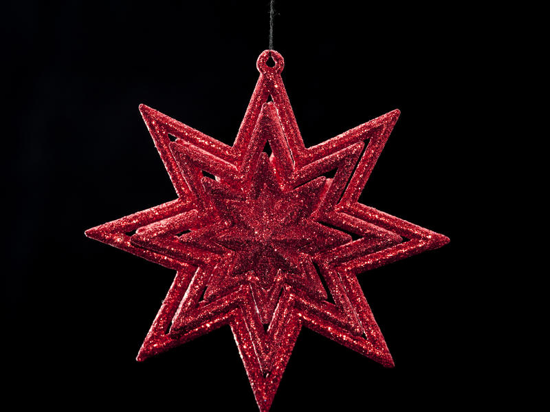 a red sparkly christmas star on black