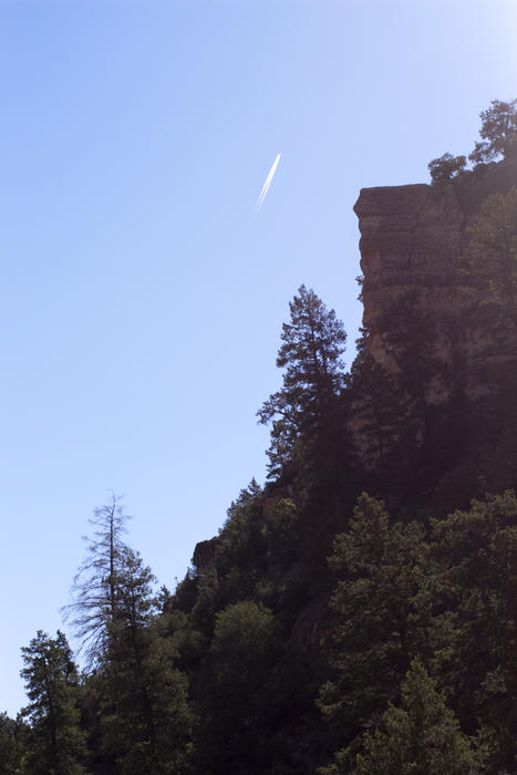 looking up at tall cliffs surround a footpath through the grand canyon
