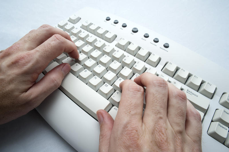 typing on a computer keyboard with two hands