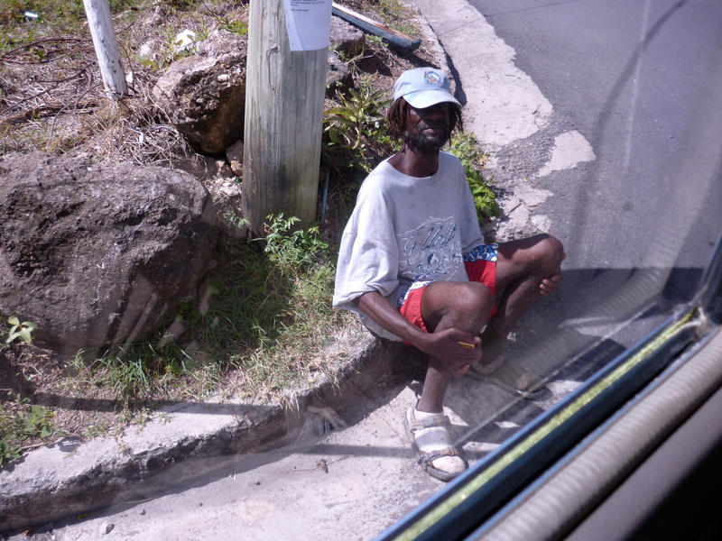 an antigua local sitting on the side of the road - not model released