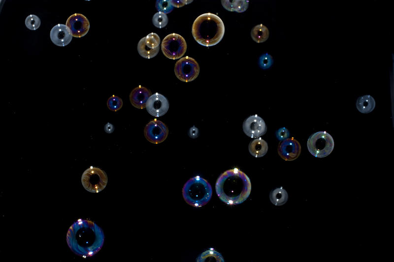 blown soap bubbles floating against a black background