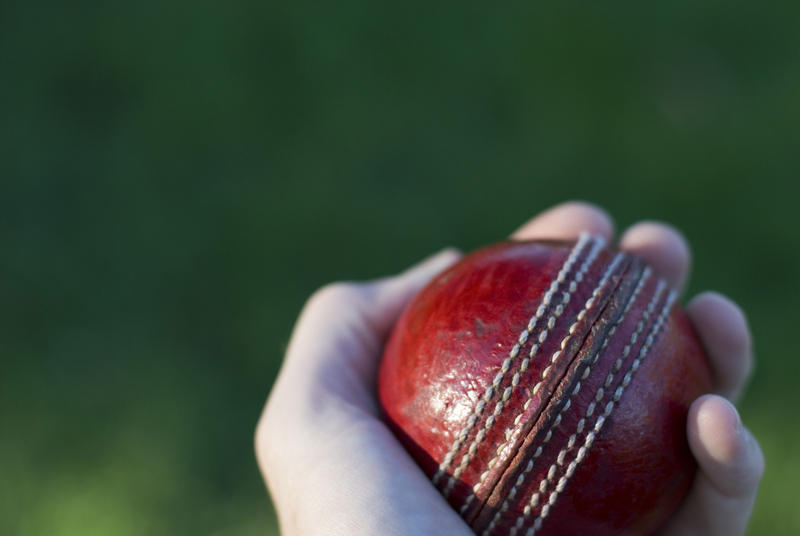 a cricket ball in hand ready to be bowled