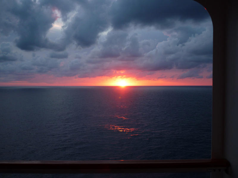 looking out at the setting sun from a cruise ship