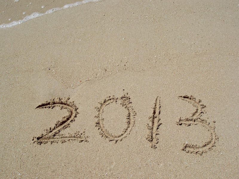 the year 2013 written on a sandy beach
