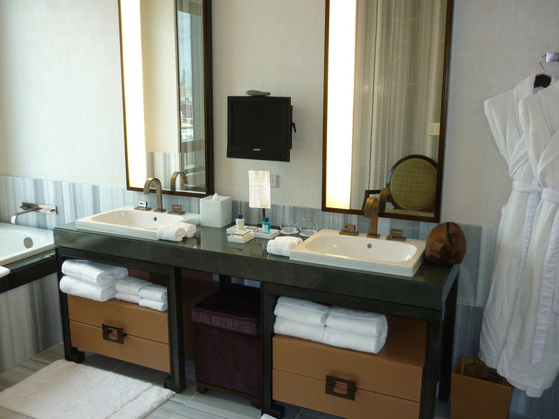 Luxury bathroom interior with a double vanity and soft fluffy white towels and a robe
