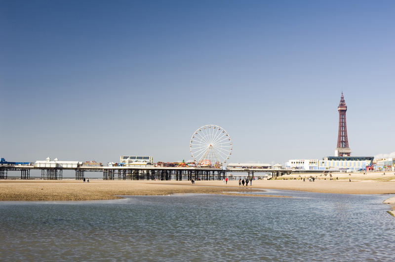 Beautiful sunny view of people on the beach in front of the Blackpool Tower and central pier in Lancashire, England