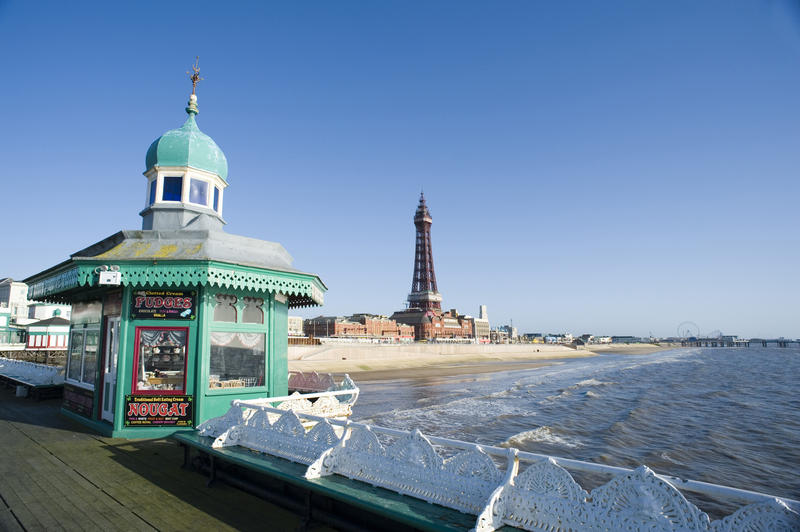 View of Blackpool Tower with a pretty ornate Victorian kiosk and white railings of the North Pier in the foreground