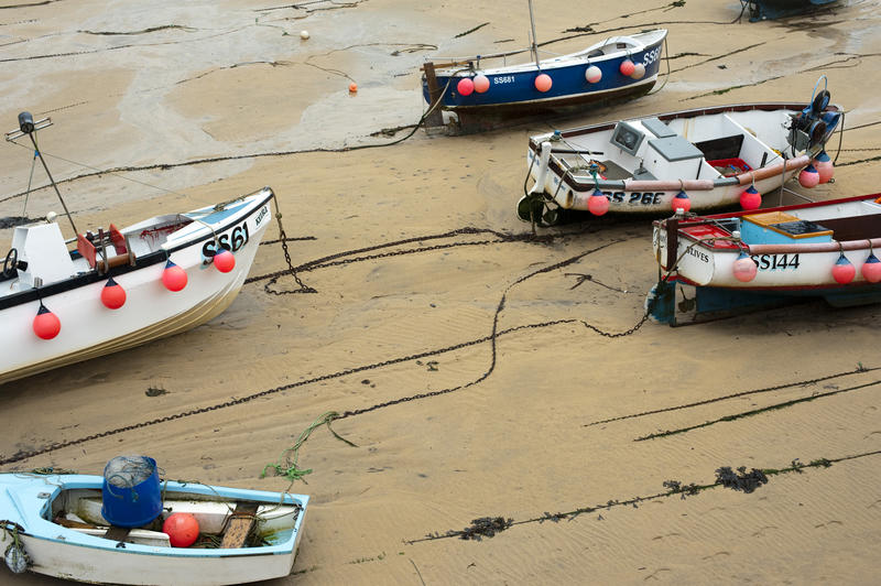 Small fishing boats beached at low tide in St Ives, Cornwall, UK