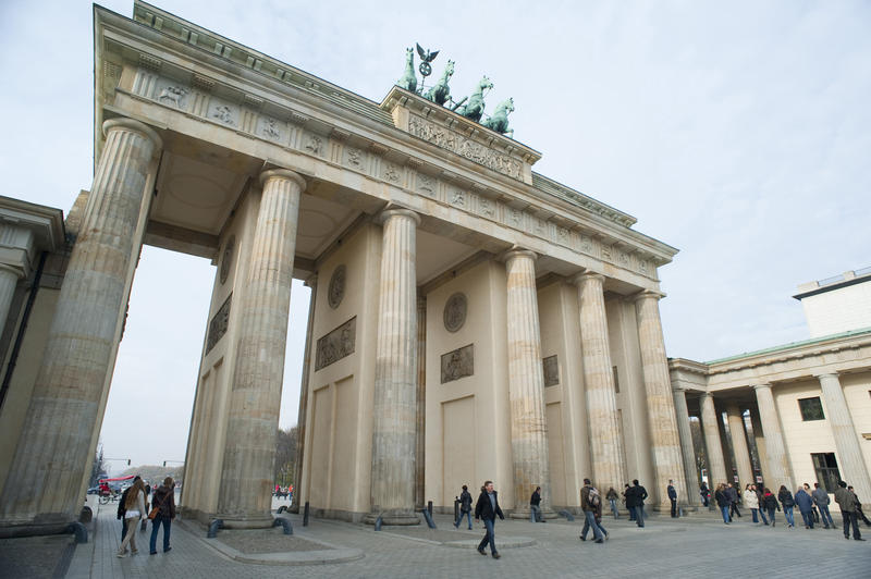 Low angle daylight view of the Brandenburg Gate, Berlin, with pedestrians in the foreground