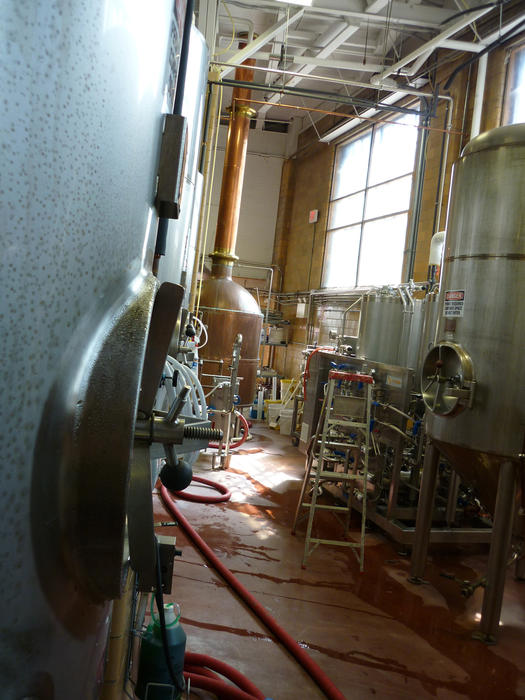 Interior of a brewery with equipment and steel vats used in the fermentation of malt to produce ale and beer