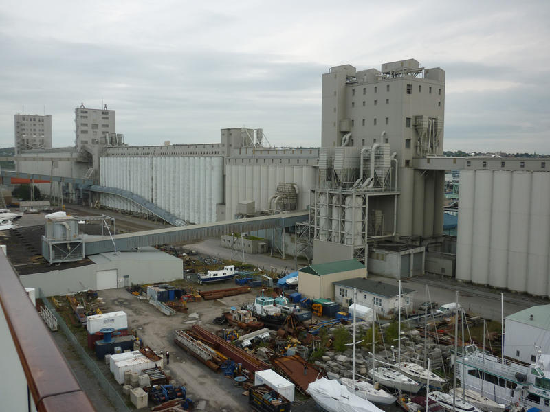 A industrial waterfront area with rows of tall grain or bulk product silos