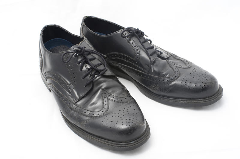 A pair of smart black leather lace up shoes for a fashionable man on a white studio background