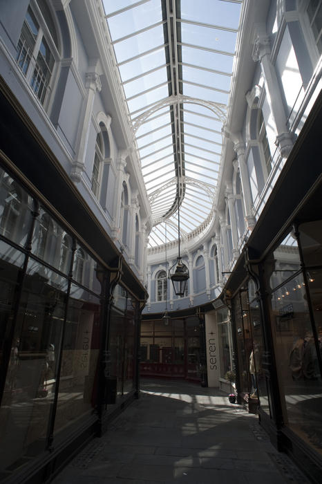 Glass roof with the original wooden shopfronts and Venetian windows in the interior of the Morgan Arcade, a restored Victorian shopping arcade in Cardiff, Wales