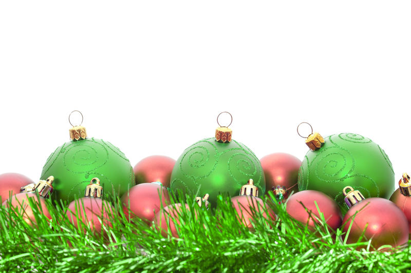 Seasonal background with copyspace of green Christmas baubles and tinsel for your festive greeting