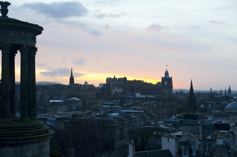 Edinburgh skyline at sunset with a colourful glow directly behind Edinburgh Rock and the Castle