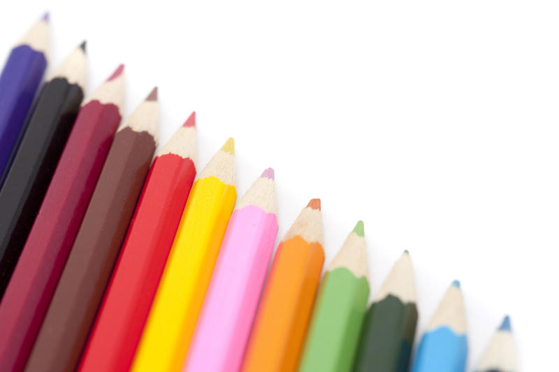 Diagonal row of coloured pencils in the colours of the spectrum with blank white copyspace for your text