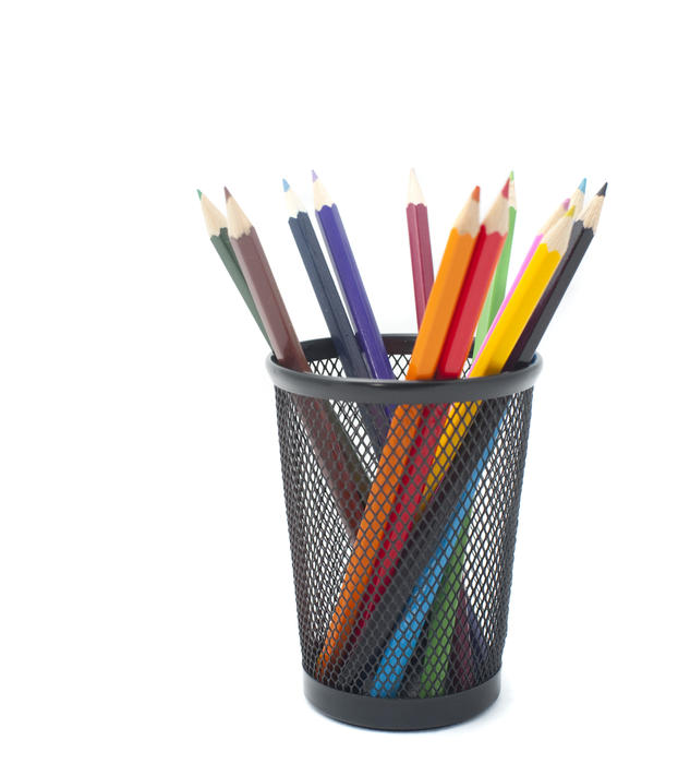 Desk tidy with filled with sharpened wooden coloured pencils on a white background