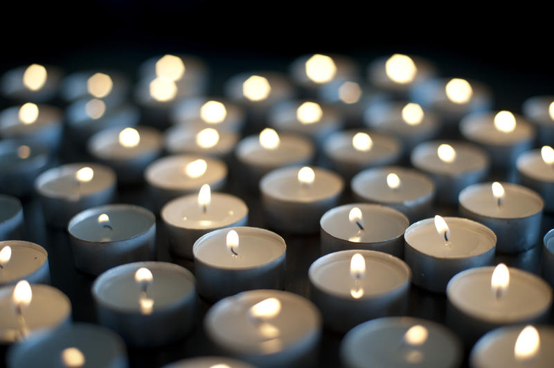 Background of burning candles of rememberance in a church, at a vigil or to celebrate a festival such as Christmas