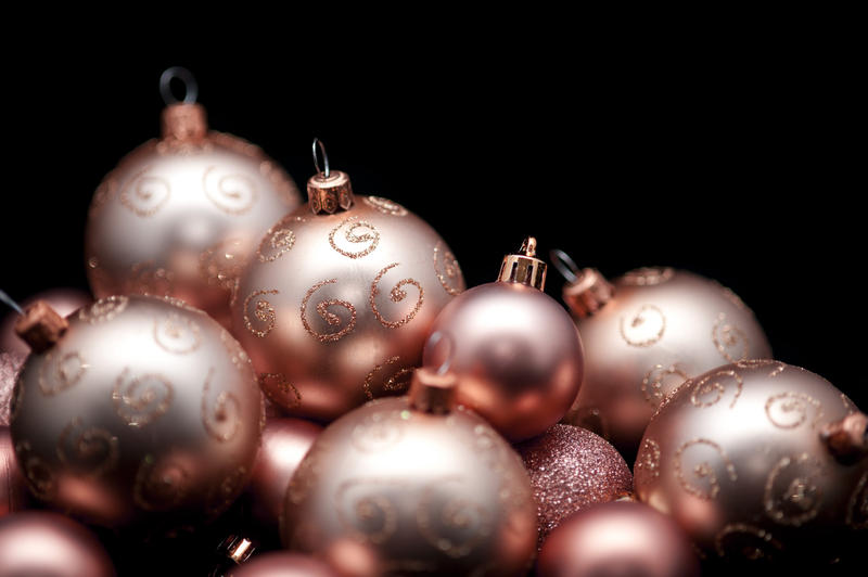 Collection of festive golden Christmas baubles against a black background with copy space