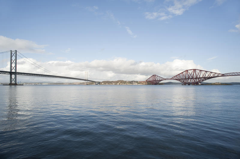 Low angle view across the water of the Firth of Forth of both the cantilever Forth Rail Bridge and the suspension Forth Road Bridge in Edinburgh, Scotland
