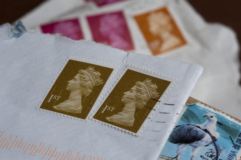 Cancelled British postage stamps on various envelopes in a communication and snail mail concept