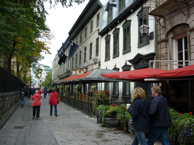 View of an urban street and sidewalk with people showing the French influence on the historic architecture in Canada