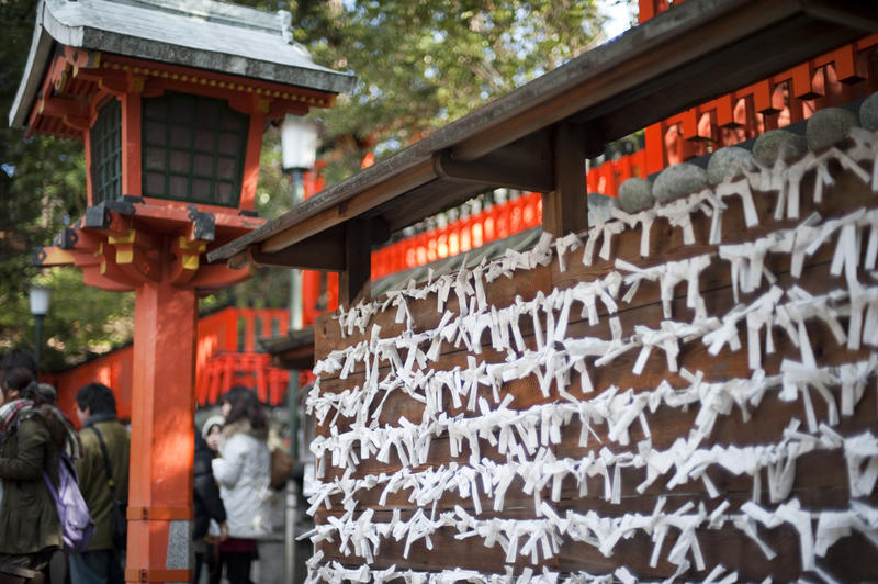 Omikuji placed by visitors to the Fushimi Inari Shrine (Fushimi Inari Taisha), Kyoto, japan