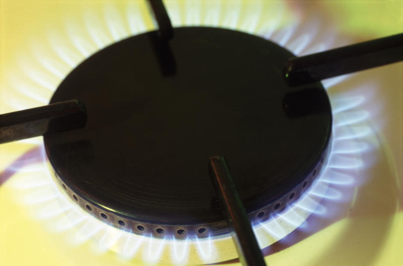 a lit gas cooker ring with a yellow colour background