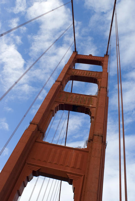 low angle view looking up at one of the distinctive red steel towers supporting the golden gate bridge, san francisco