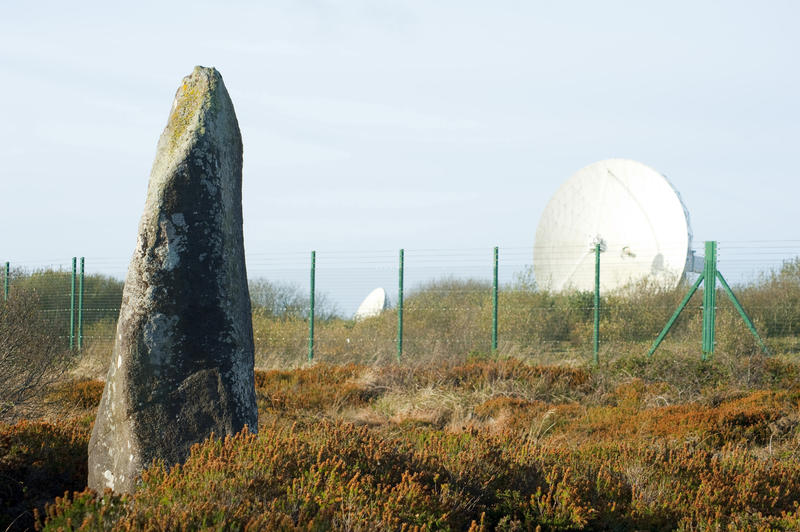 View from the perimeter of large parabolic satellite dishes at the BT Groups Goonhilly Satellite Earth Station on the Lizard Peninsula Cornwall with an upright stone in the foreground