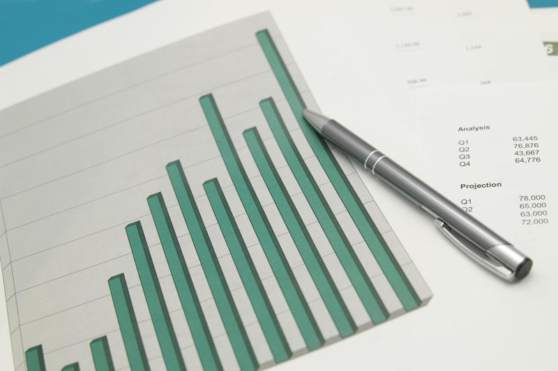 Bar graph or chart analysis with a ballpoint pen lying across an ascending bar graph showing successful growth