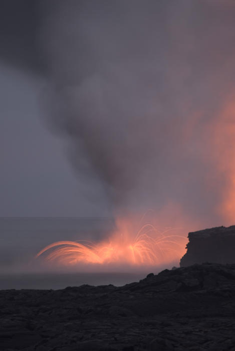 amazing view of lava entering the ocean and spewing clouds of steam, near Kalapana, Hawaiis Big Island 