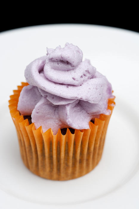 a small cup cake with purple icing on top