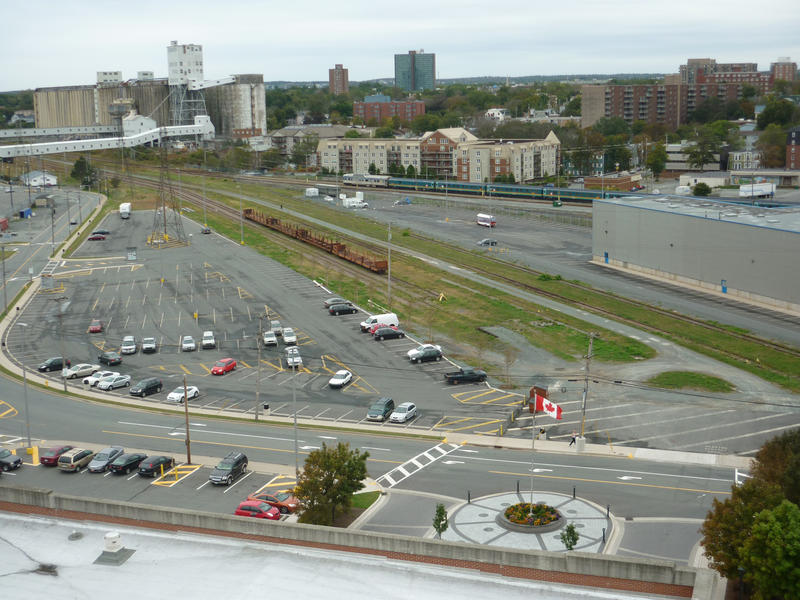 View of the industrial district of Halifax, Canada with a carpark, warehouse and railway siding with highrise buildings in the distance