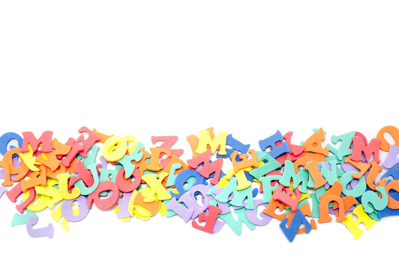 Line of jumbled colourful alphabet letters lying on a white background with copyspace for your education concept