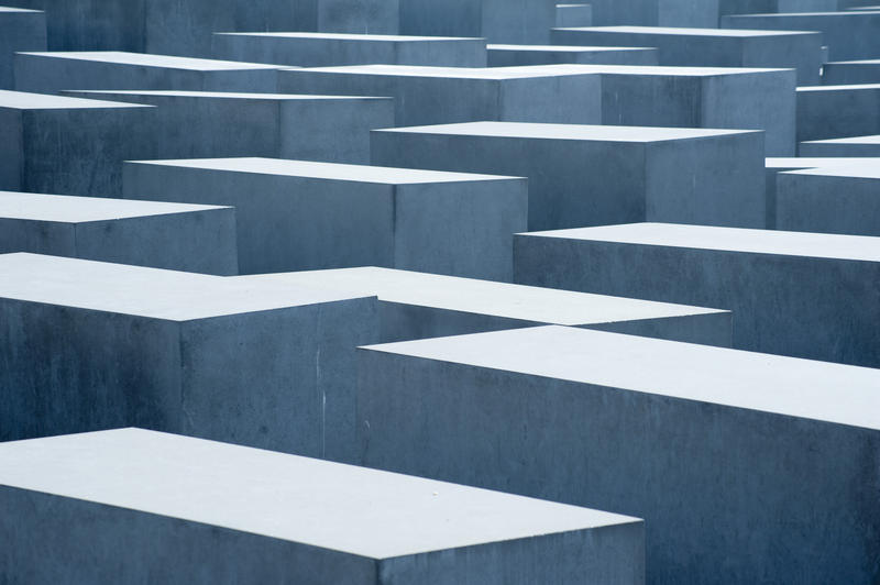 a somber image of the berlin holocaust memorial, a vast array of featureless stone blocks