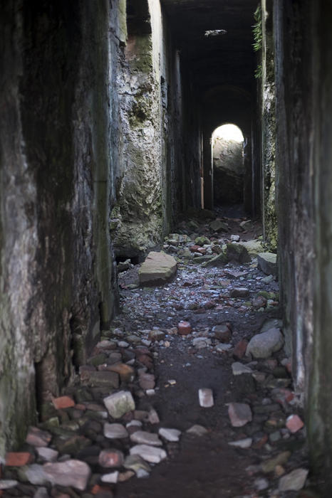 Looking down a derelict paasageway strewn with rubble inside the Levant mine powerhouse ruin near Pendeen, Cornwall, now protected by the Cornwall and West Devon Mining Landscape World Heritage site
