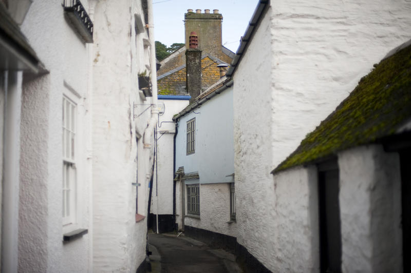 Quaint narrow lanes winding between white-washed fishermans cottages in the popular tourist village of Polperro in Cornwall