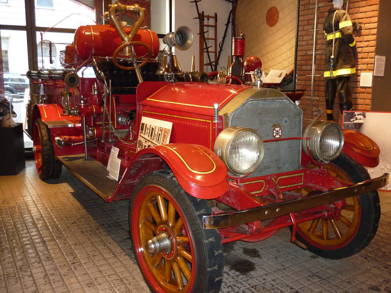 Beautifully restored historical vintage red firetruck on display in a showroom