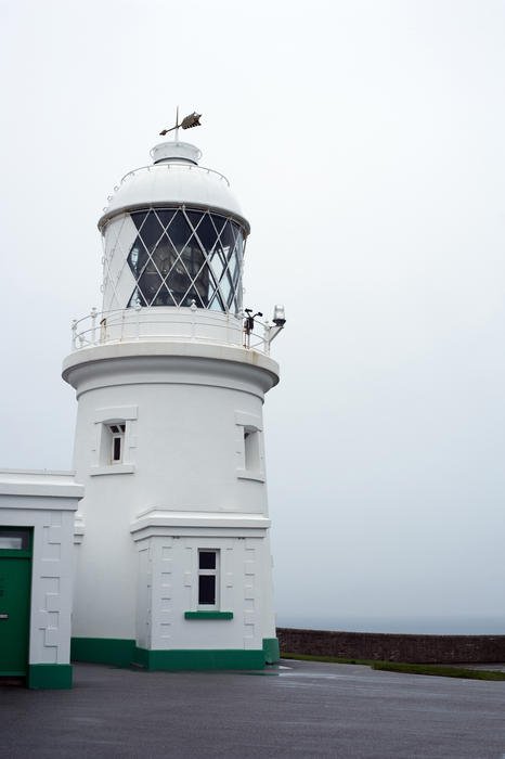 Closeup view of the cylindrical Pendeen lighthouse in Cornwall with its large lantern for warning shipping of coastal hazards