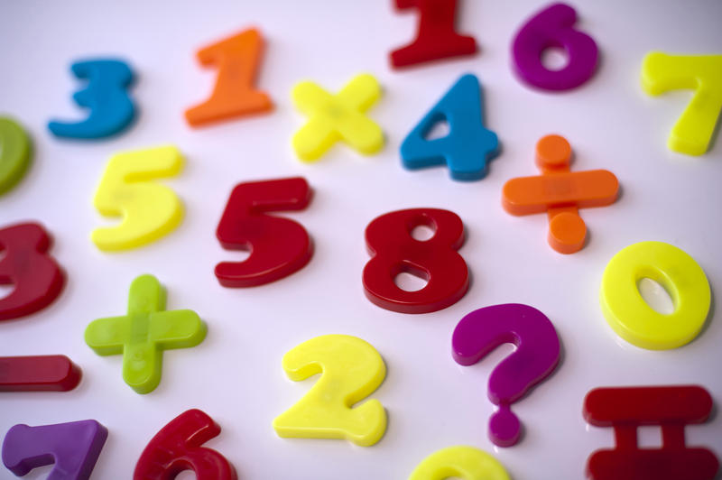 Colorful stick-on numbers and mathematical symbols on a fridge door