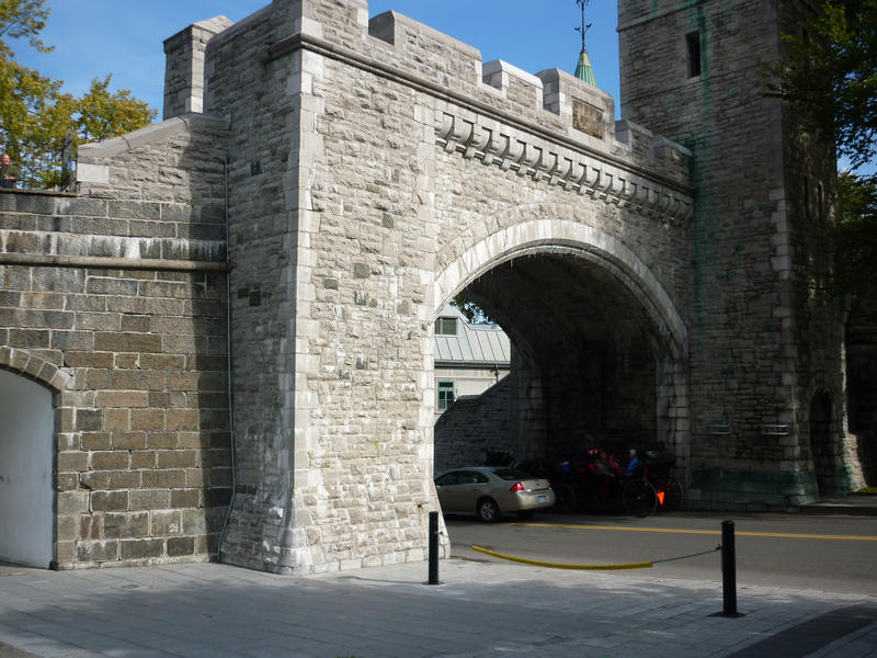 Historic fortified walls of Quebec City with a roadway running under a stone arch