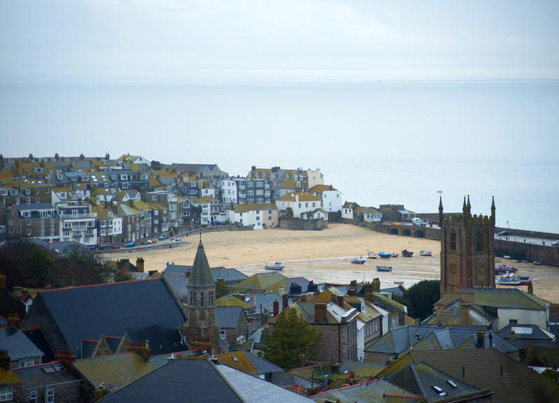 View across the rooftops of Saint Ives, Cornwall towards the harbour and waterfront at low tide