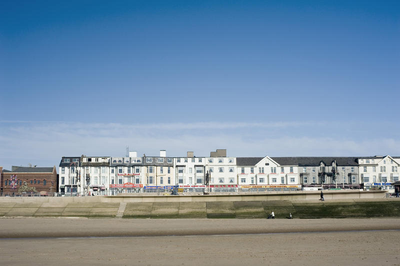 View from the beach of a row of Blackpool seafront guest houses along the promenade overlooking the ocean