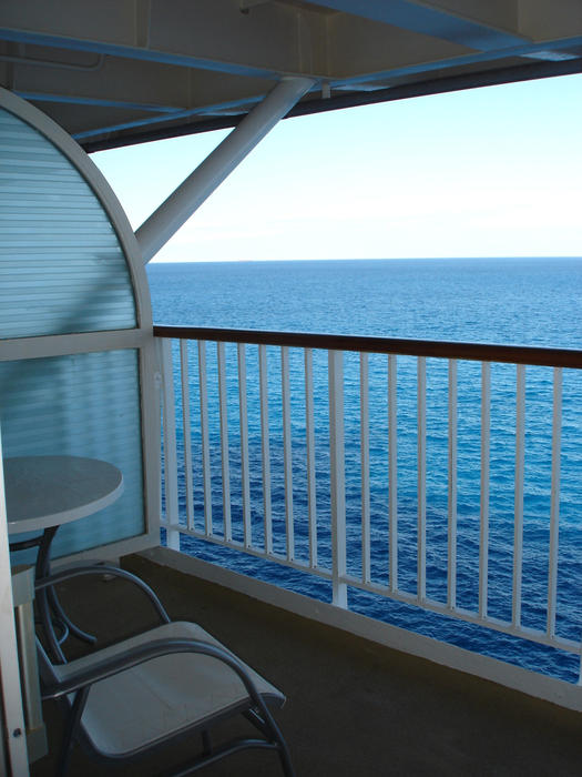 View from a ships balcony on a passenger cruise liner out over the blue ocean while on a long vacation and voyage