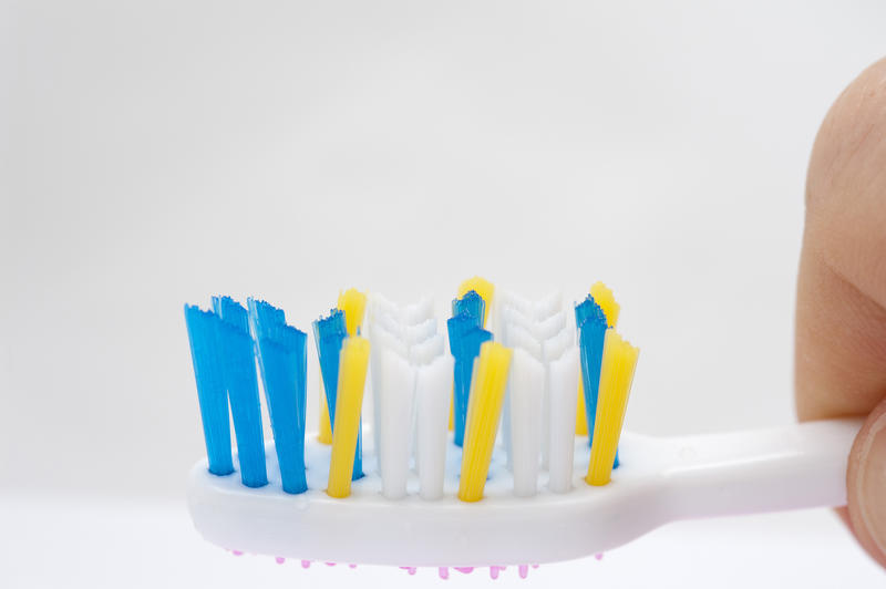 Closeup of a toothbrush head with colourful bristles of varying lengths to ensure maximum coverage for removal of bacteria and plaque