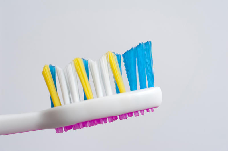 Toothbrush head with colourful bristles and a pink tongue scrubber to clean the surface of the tongue while brushing your teeth